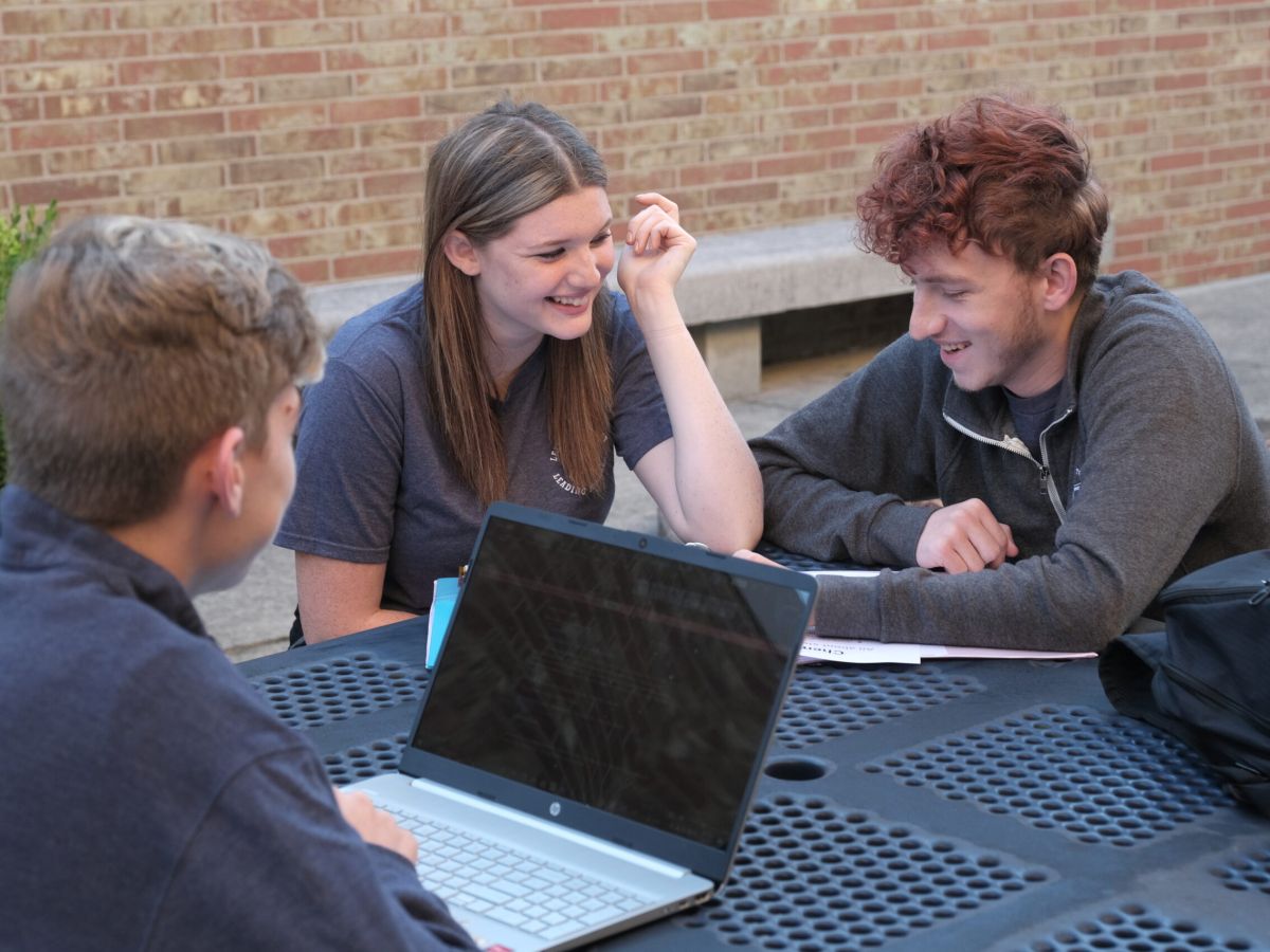 students at an outdoor table studying