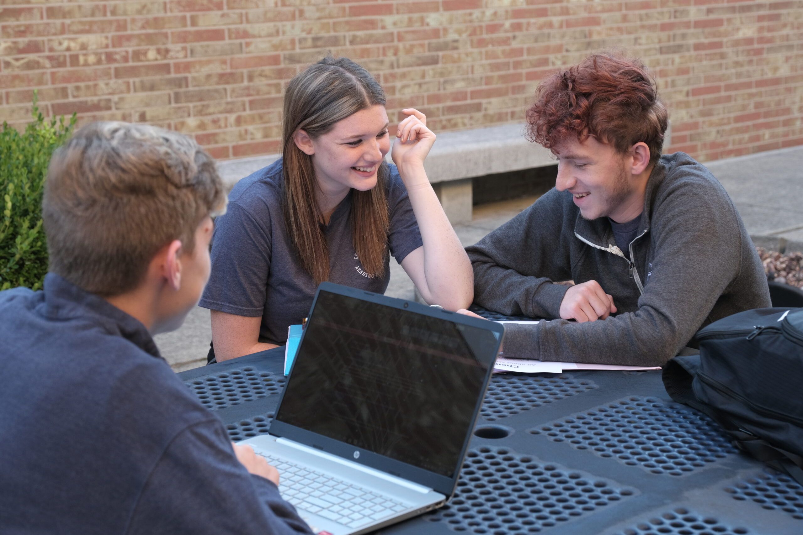 students at an outdoor table studying