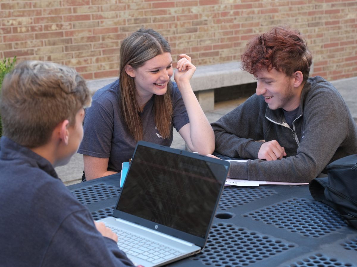 students at an outdoor table studying